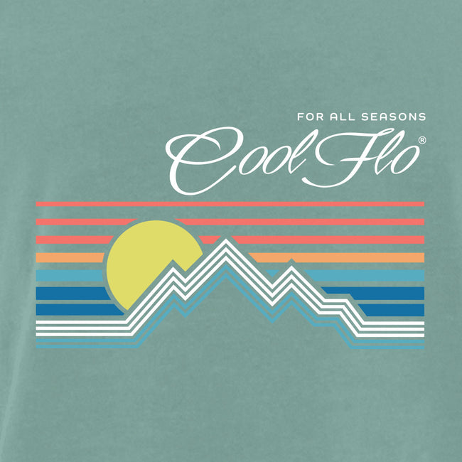 Close-up of Cool Flo green t-shirt with a graphic design featuring a mountain sunset depicted by lines. For all seasons.