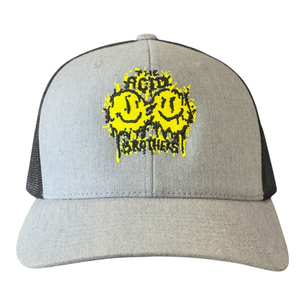 The Acid Brothers grey and back trucker cap with black and yellow embroidered 'smileys' logo.