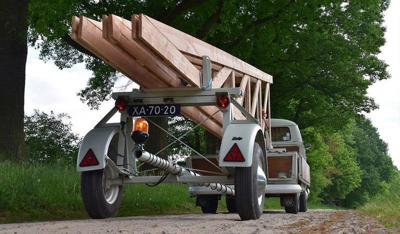 Rear view of vintage VW pick-up truck towing a rare long load trailer.