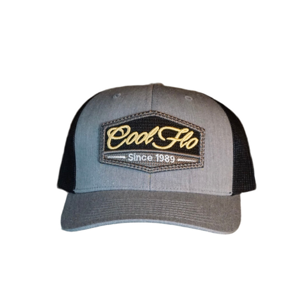 Grey and black trucker cap with Cool Flo Since 1989 puff-embroidered badge sewn onto front.