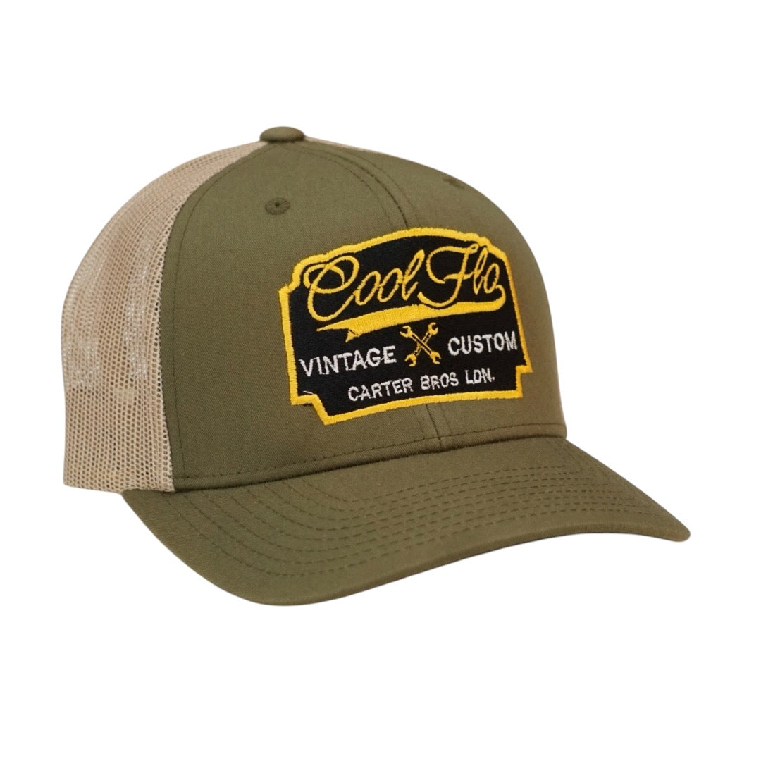 Cool Flo Vintage Custom. Green and khaki trucker cap with embroidered yellow, black and white badge with cross-spanners. Carter Bros. London.