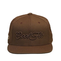 Front view of a Cool Flo Tan snapback cap featuring a matching raised 3D embroidered Script logo and flat visor