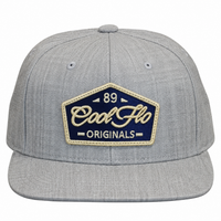 Front view of a Cool Flo 89 Originals snapback cap in Heather Grey featuring an embroidered 89 Originals badge in Navy, Gold and White and a flat visor.