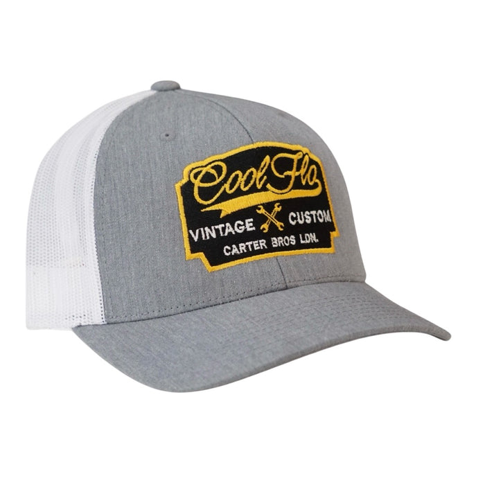 Cool Flo Vintage Custom. Grey and white trucker cap with embroidered yellow, black and white badge with cross-spanners. Carter Bros. London.