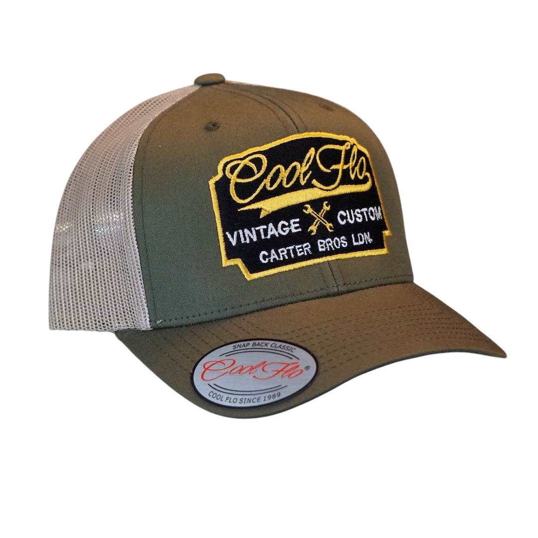 Cool Flo Vintage Custom. Green and khaki trucker cap with embroidered yellow, black and white badge with cross-spanners. Carter Bros. London.