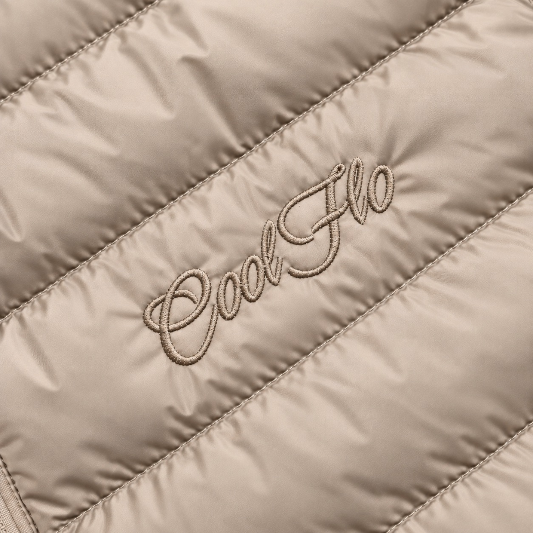 Close-up of tonal Cool Flo Script embroidery on a desert dust quilted jacket.