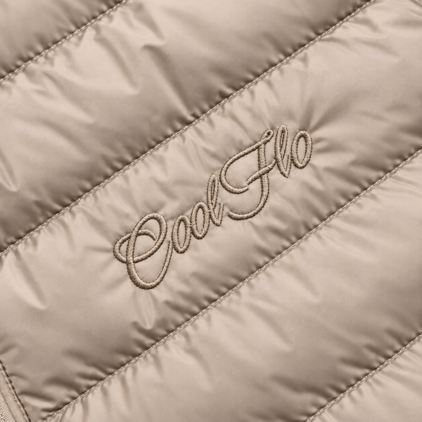 Close-up of tonal Cool Flo Script embroidery on a desert dust quilted jacket.