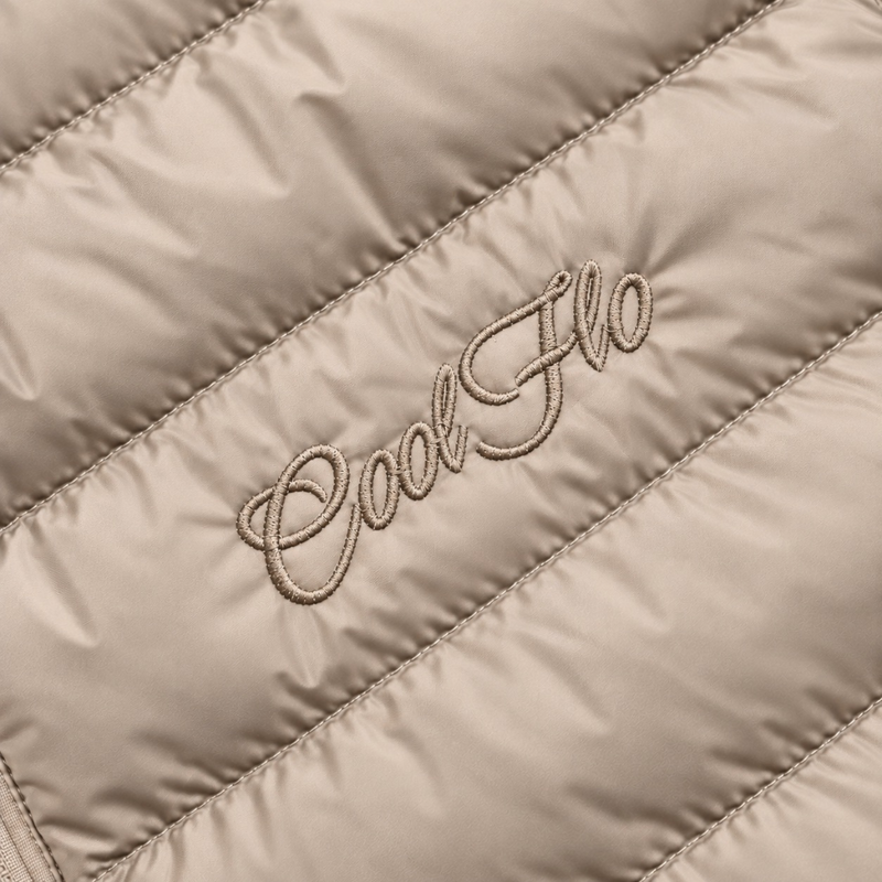 Close-up of tonal Cool Flo Script embroidery on a desert dust quilted jacket.