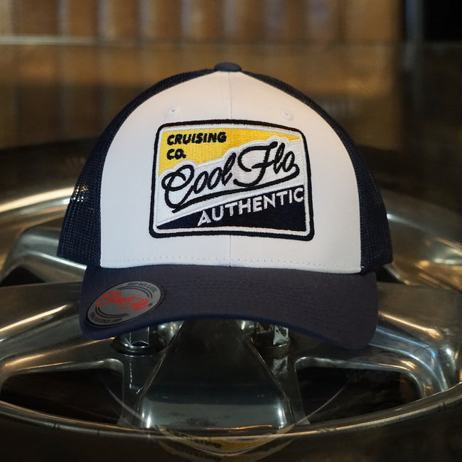 Cool Flo Authentic Cruising Co - Trucker cap with navy peak and mesh and a white front with a yellow, white and navy embroidered badge design