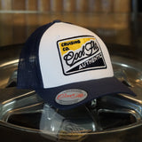 Cool Flo Authentic Cruising Co - Trucker cap with navy peak and mesh and a white front with a yellow, white and navy embroidered badge design.