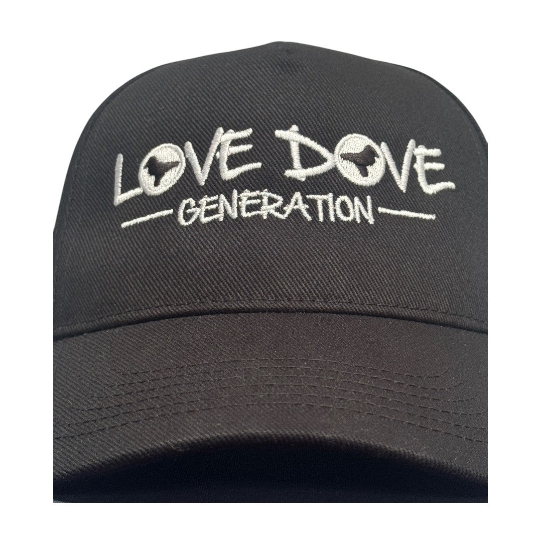 Black baseball cap with embroidered white 'Love Dove Generation' on the front_close up of embroidered logo.