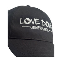 Black baseball cap with embroidered white 'Love Dove Generation' on the front_close up of embroidered logo.