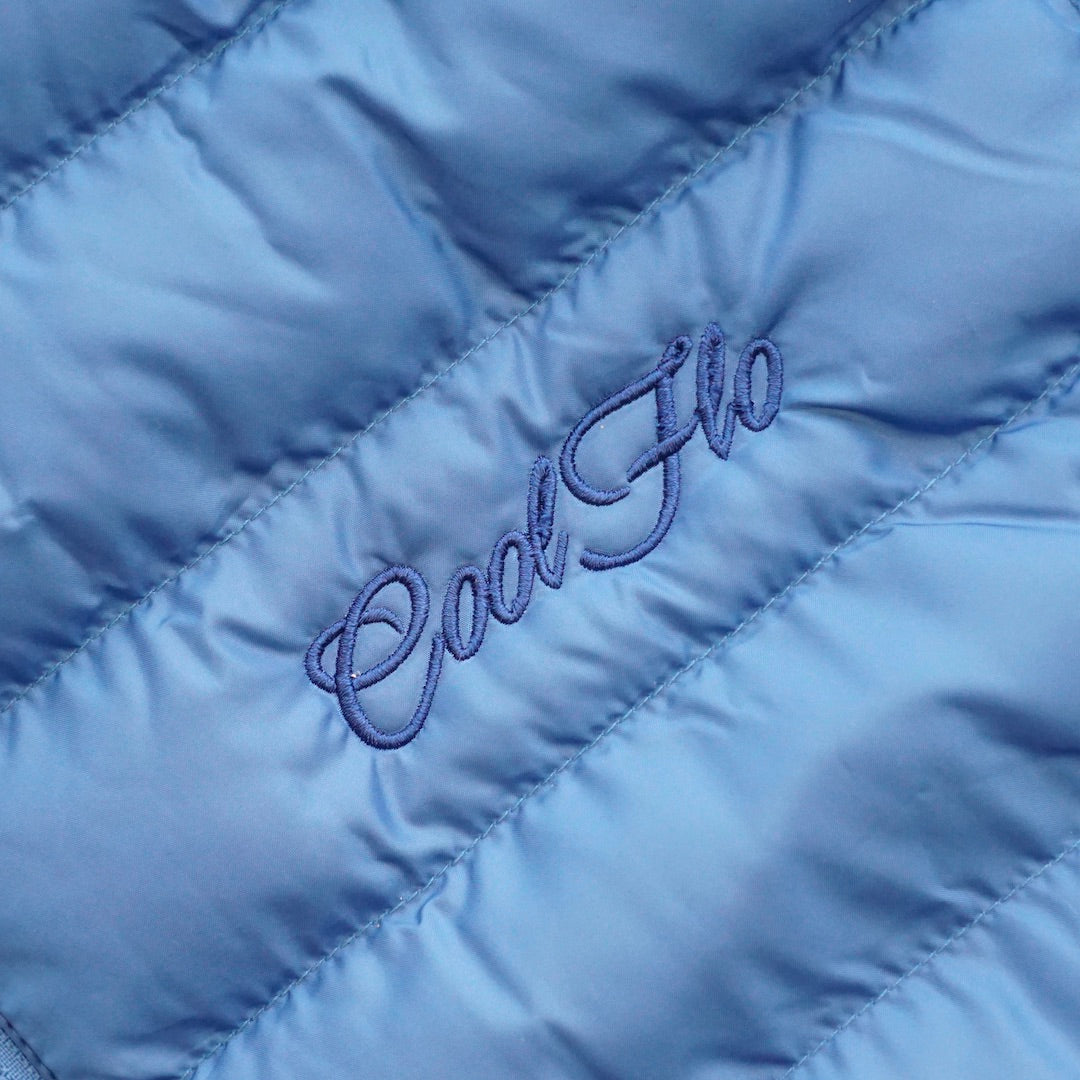 Close-up of premium blue puffer jacket with matching Cool Flo script logo embroidered on the left.