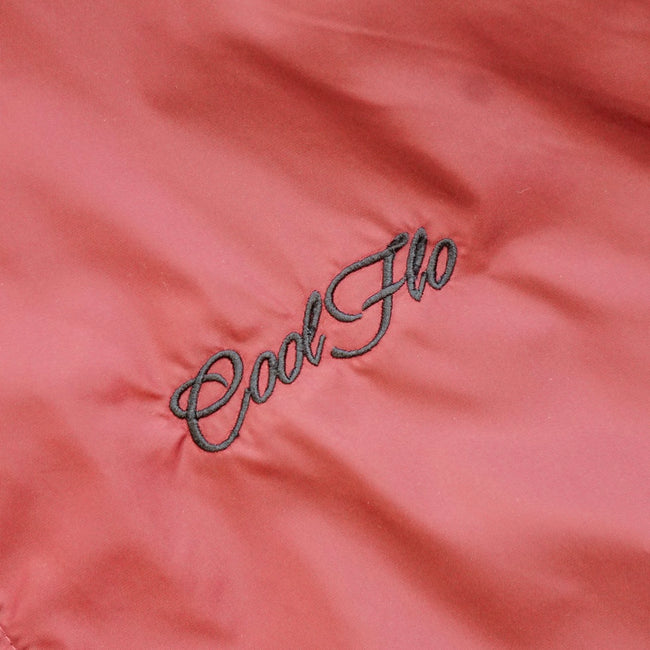 Close-up of embroidery on Burgundy and black wind runner jacket with black Cool Flo script logo embroidered on the left. 