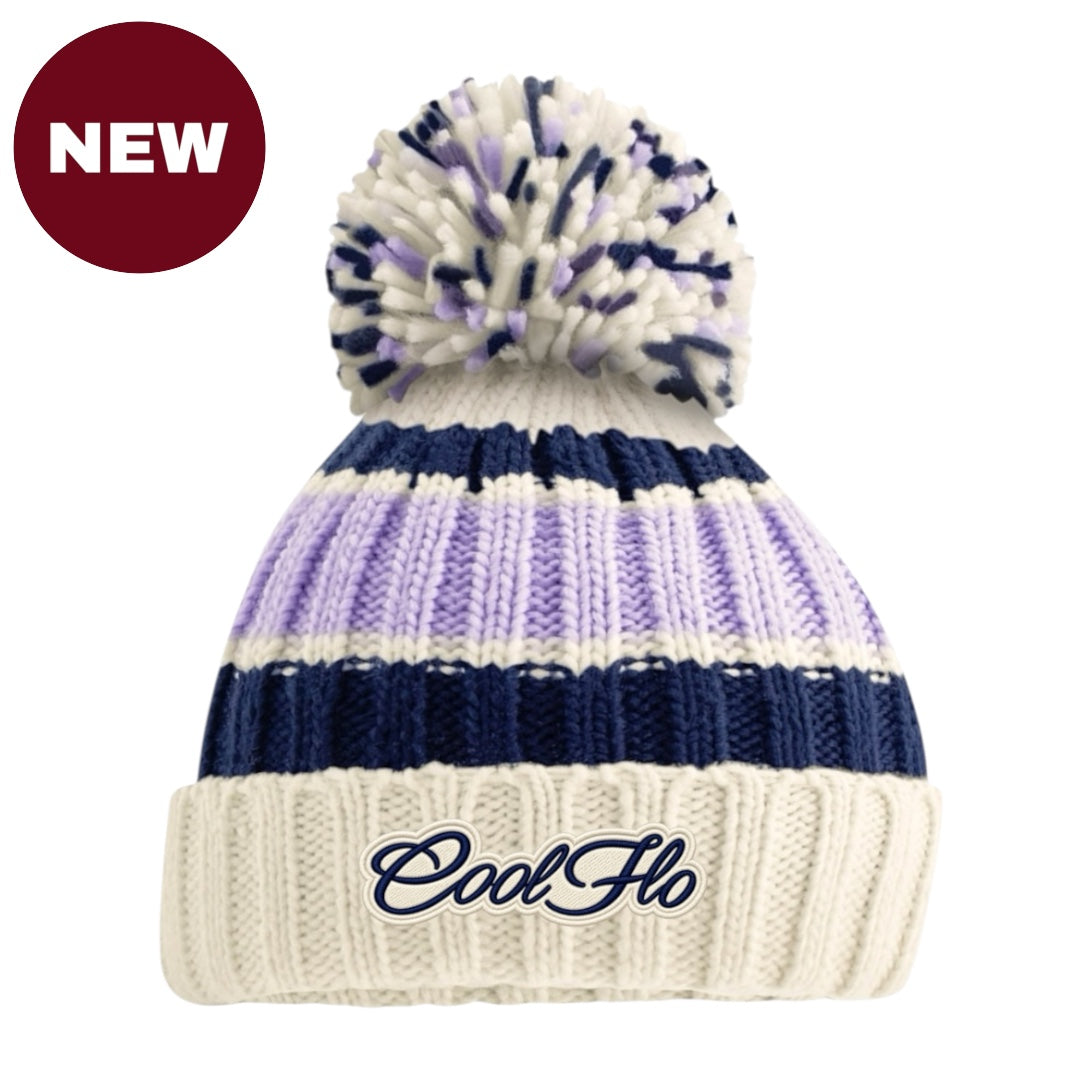 A cream, lilac and navy knit pom-pom beanie with a navy embroidered 'CoolFlo' logo on the front cuff, shown on a white background with a red 'NEW' badge in the top-left corner.