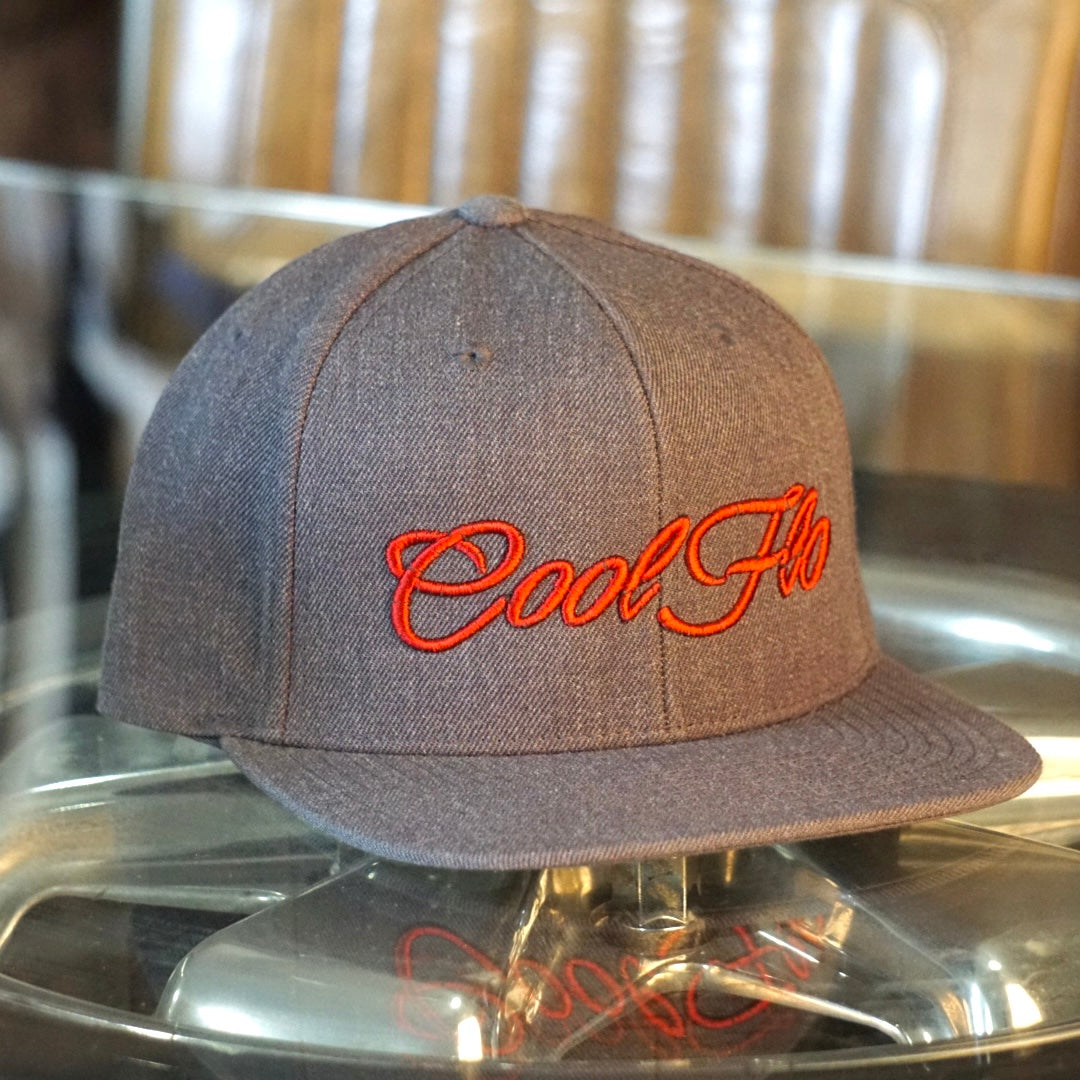 Dark grey snapback cap with red 3D embroidered Cool Flo script logo on the front.