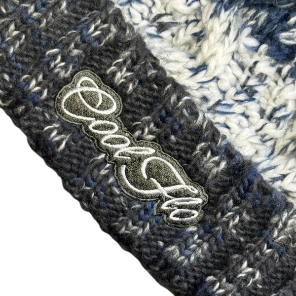 Close-up of Cool Flo Morzine bobble hat in Midnight Summit colour way with an embroidered logo on the cuff.