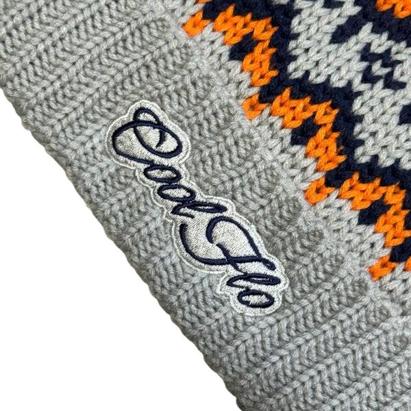 Close-up of Cool Flo Arctic Glacier Trails Beanie in a grey, navy and orange colour way with matching grey and navy embroidered logo.