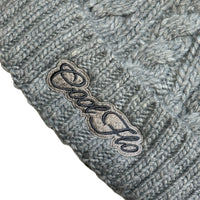Close-up of Cool Flo Cable Knit Bobble Hat in Light Grey with light and dark grey Cool Flo embroidered logo on the cuff.