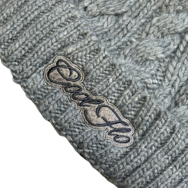 Close-up of Cool Flo Cable Knit Bobble Hat in Light Grey with light and dark grey Cool Flo embroidered logo on the cuff.