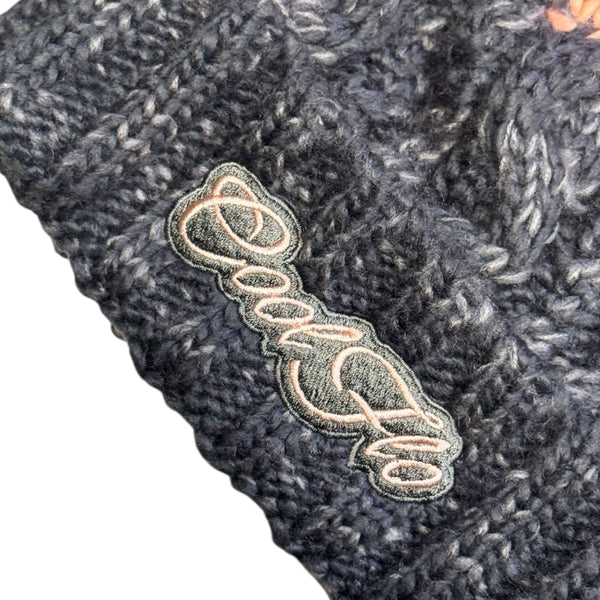 Close-up of Cool Flo Chamonix Bobble Hat in Grey/Pink with matching Cool Flo embroidered logo on the cuff.
