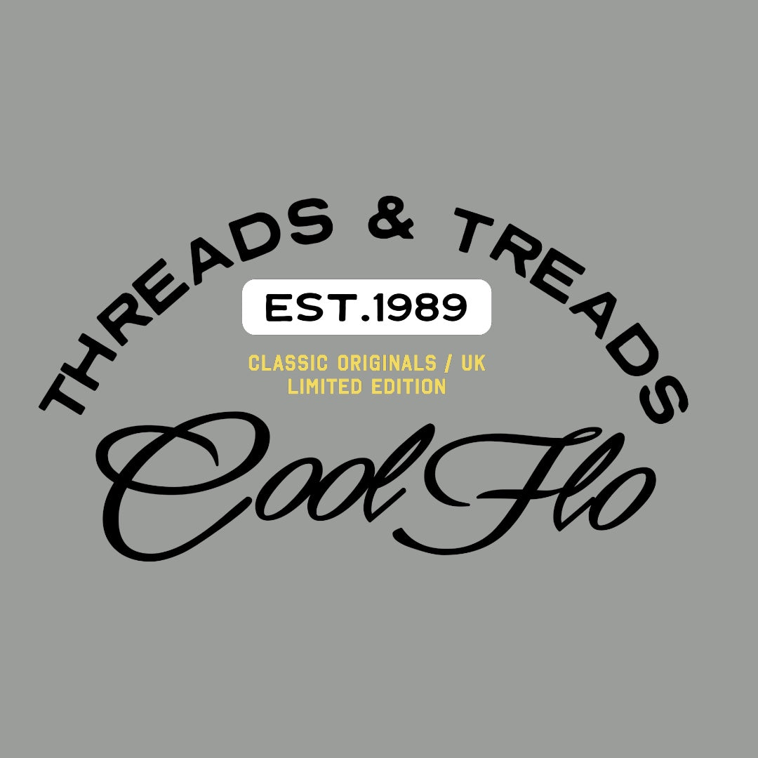 Close up of Threads & Treads print in black, white and yellow on a misty grey t-shirt.