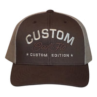 A dark brown custom trucker hat with  khaki mesh side panels. The front features white embroidered text reading 'CUSTOM' with 'Cool Flo' in cursive underneath and 'CUSTOM EDITION' with star accents.