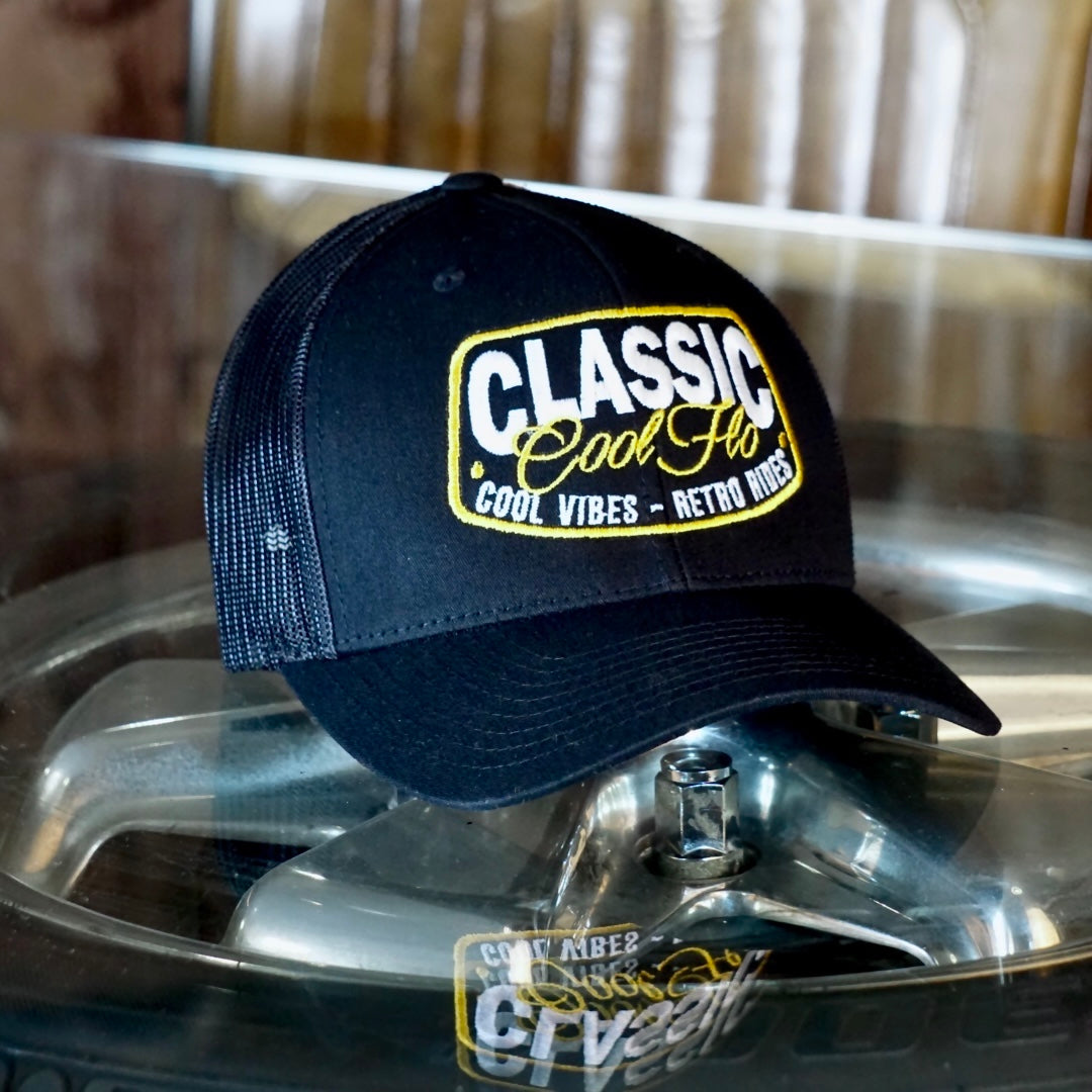 Coo Flo brown and khaki trucker cap with embroidered yellow and white 'Classic, cool vibes, retro rides' design.