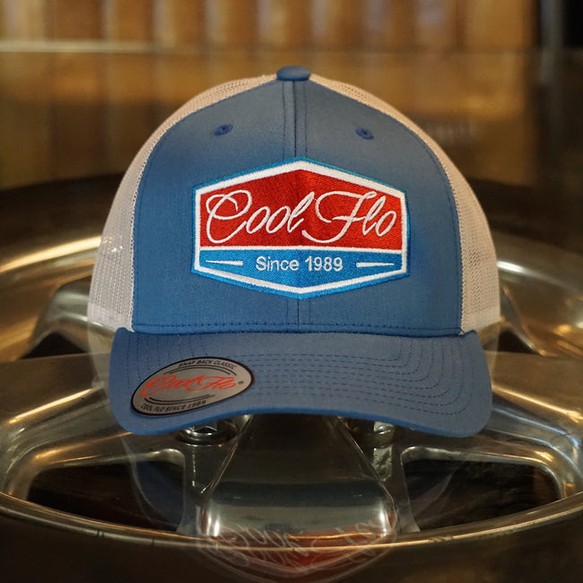 Cool Flo Blue and silver-grey two-tone trucker caps with turquoise, red and white embroidered badge design on the front.Cool Flo - Since 1989