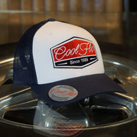 Cool Flo Navy Blue and white contrast trucker cap with navy, red and white embroidered badge design on the front.Cool Flo - Since 1989