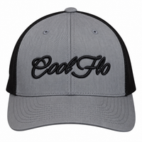 A heather grey trucker cap with black mesh side/back panels and black embroidered 'Cool Flo' script on the front, shown against a classic car.