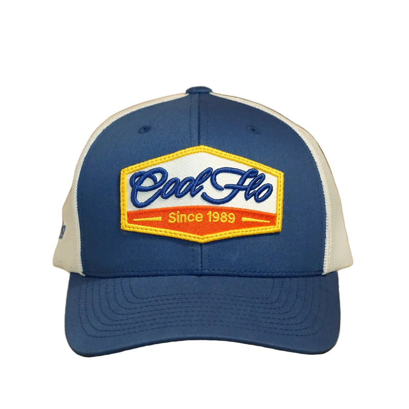 Front view of a Cool Flo Since 1989 trucker cap in Blue/White featuring an embroidered Cool Flo Since 1989 badge in Blue, Yellow and White and a curved visor