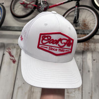 Front view of a Cool Flo Since 1989 trucker cap in White featuring an embroidered Since 1989 badge in Orange and White and a curved visor