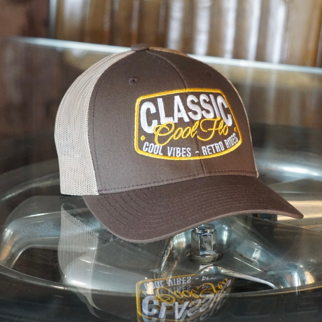 Cool Flo brown and khaki trucker cap with embroidered yellow and white 'Classic, cool vibes, retro rides' design.