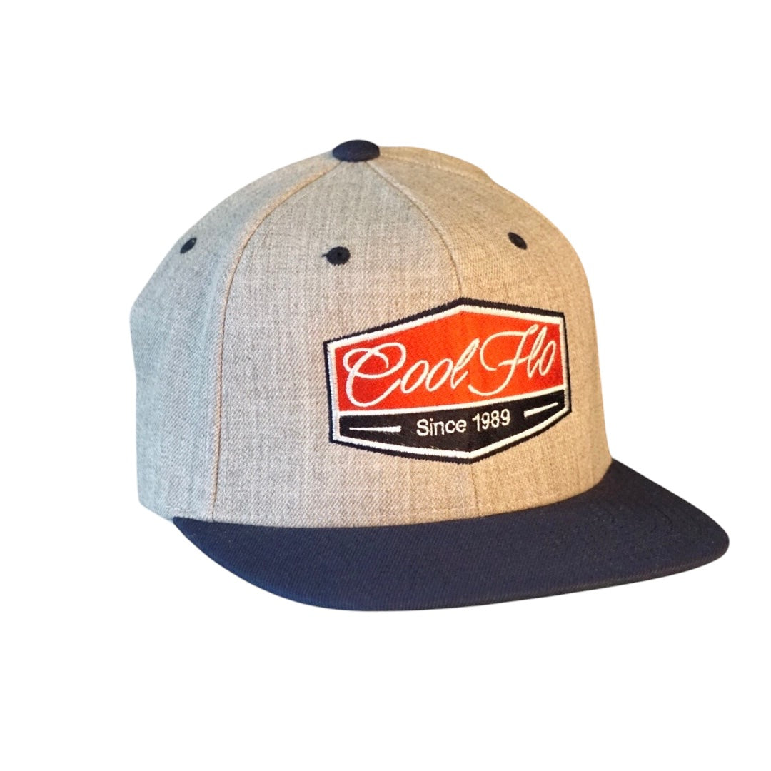 Navy and grey two-tone snapback cap with navy, red and white badge design - Cool Flo - Since 1989.