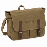 A desert sand canvas messenger bag with dark brown leather straps and a matching top handle, featuring the brand name 'Cool Flo' embroidered on the front flap.