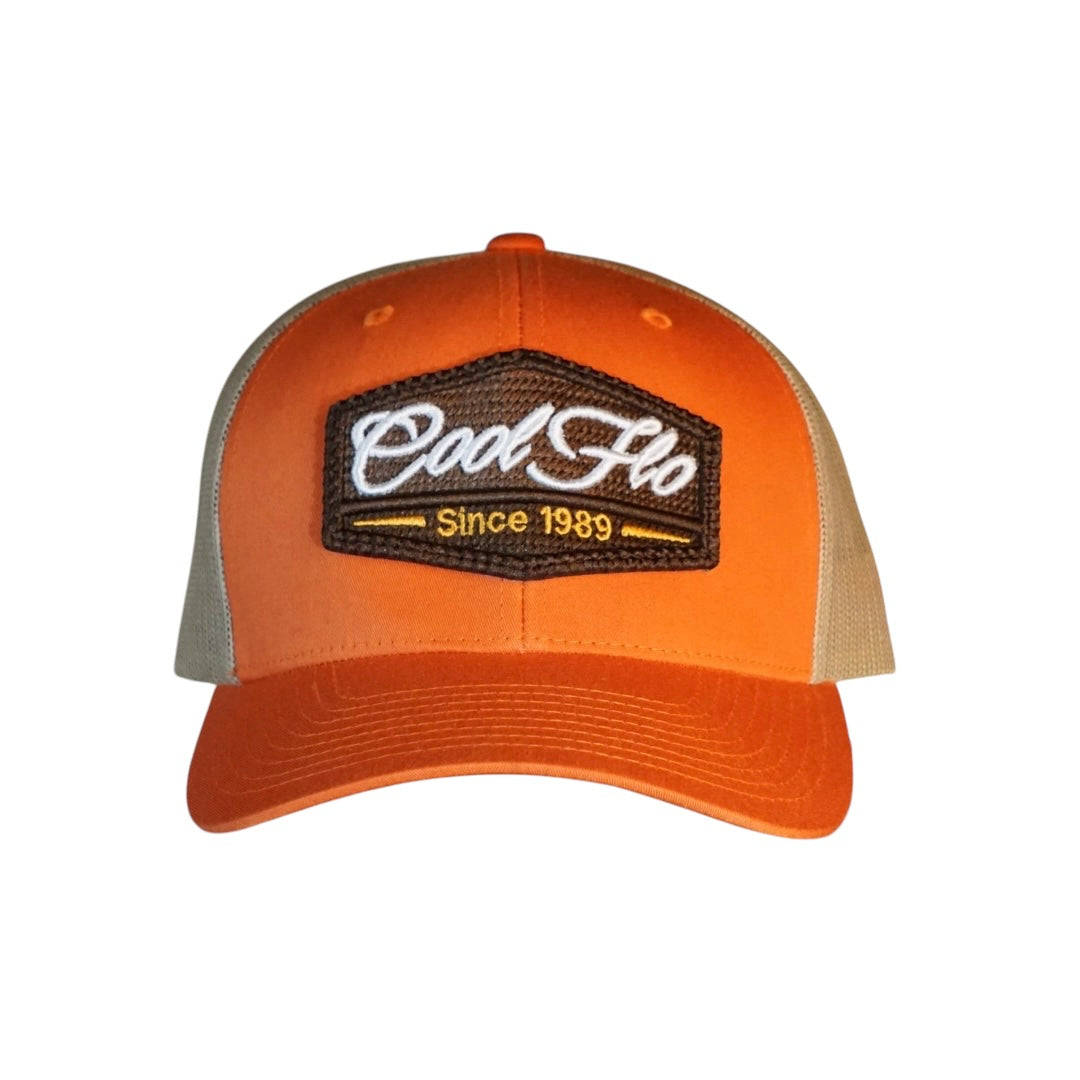 Cool Flo orange and khaki trucker cap with brown, white and orange 3D puff embroidered badge sewn onto the front.