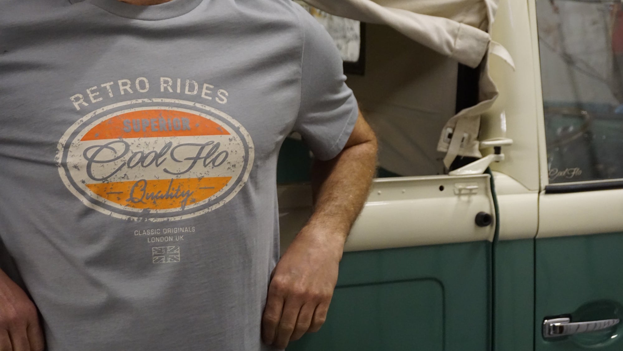 Model wearing a grey Cool Flo t-shirt with a retro-style 'Retro Rides' graphic, standing next to a vintage green and cream Volkswagen pick-up truck.