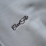 Close-up of navy Cool Flo script logo embroidery on a light blue zip hoody