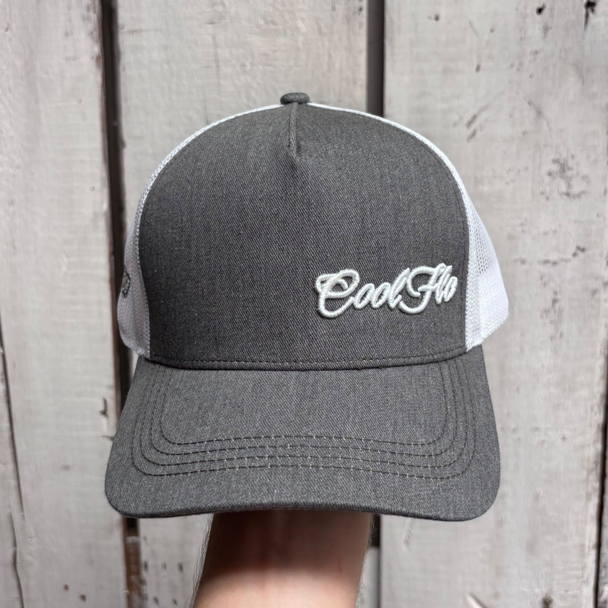 Front view of a Cool Flo Grey/White Trucker cap featuring an embroidered Mini Script logo positioned on the front left panel.