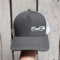 Front view of a Cool Flo Grey/White Trucker cap featuring an embroidered Mini Script logo positioned on the front left panel.