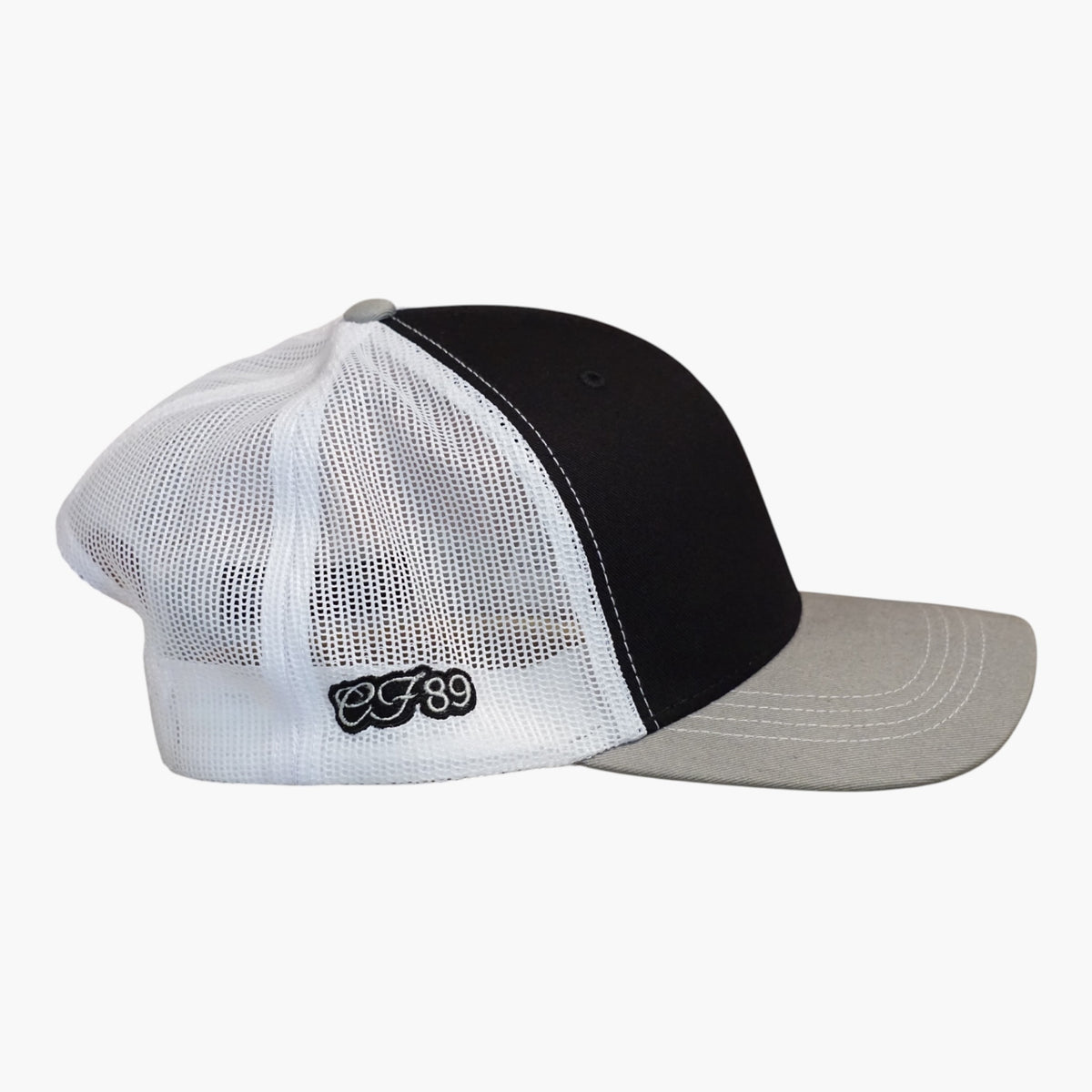 Side view of a Cool Flo Grey/Black/White Trucker cap featuring CF89 embroidered side detail and breathable mesh back panels.