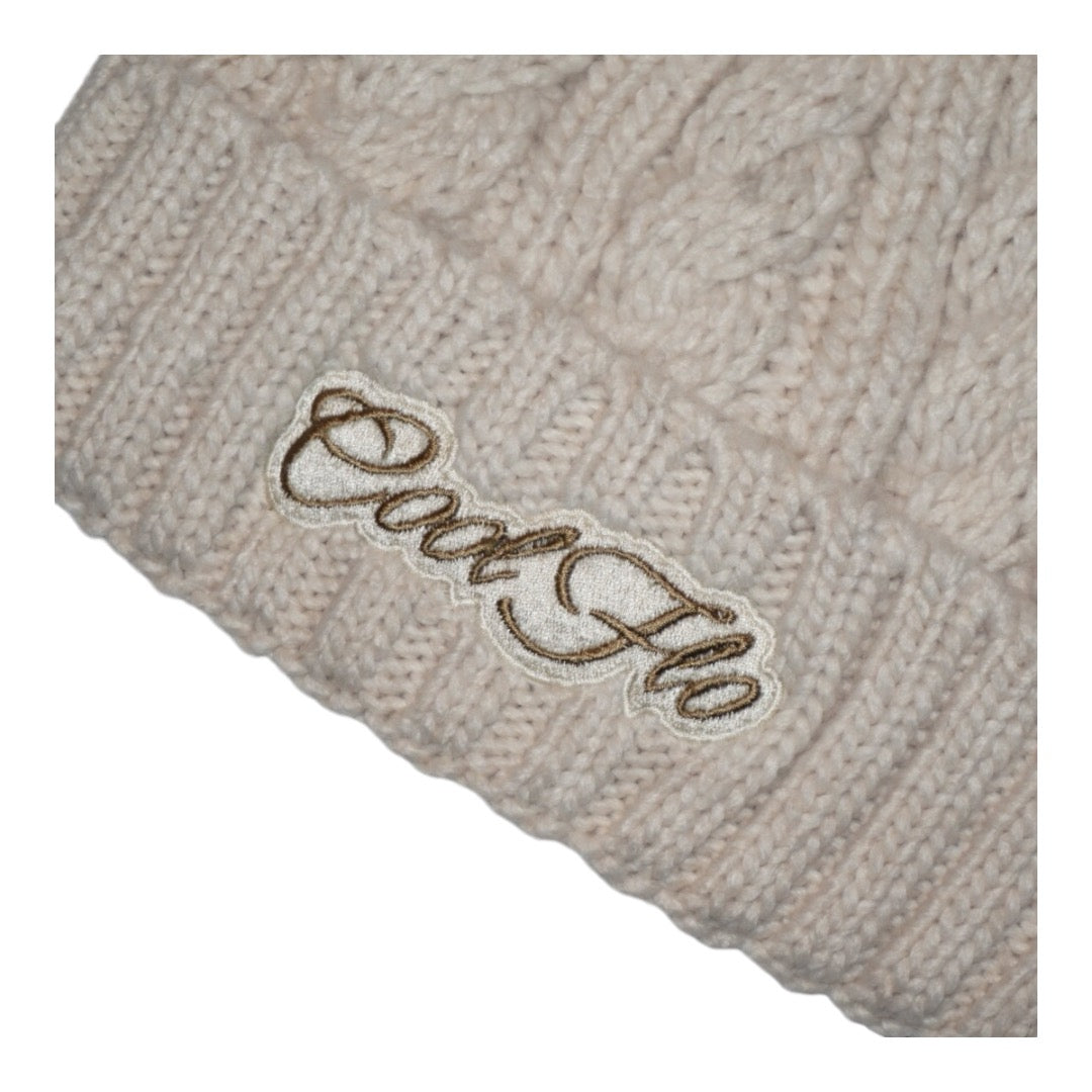 Cable knit bobble hat with script logo. Oatmeal.