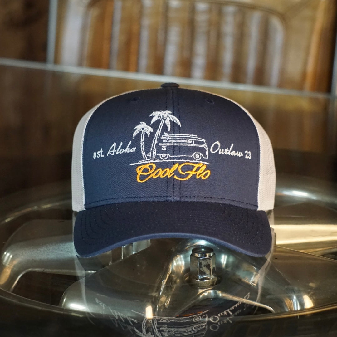 Aloha Outlaw two-tone navy and silver/grey trucker cap with embroidered VW bus and palm tree design.