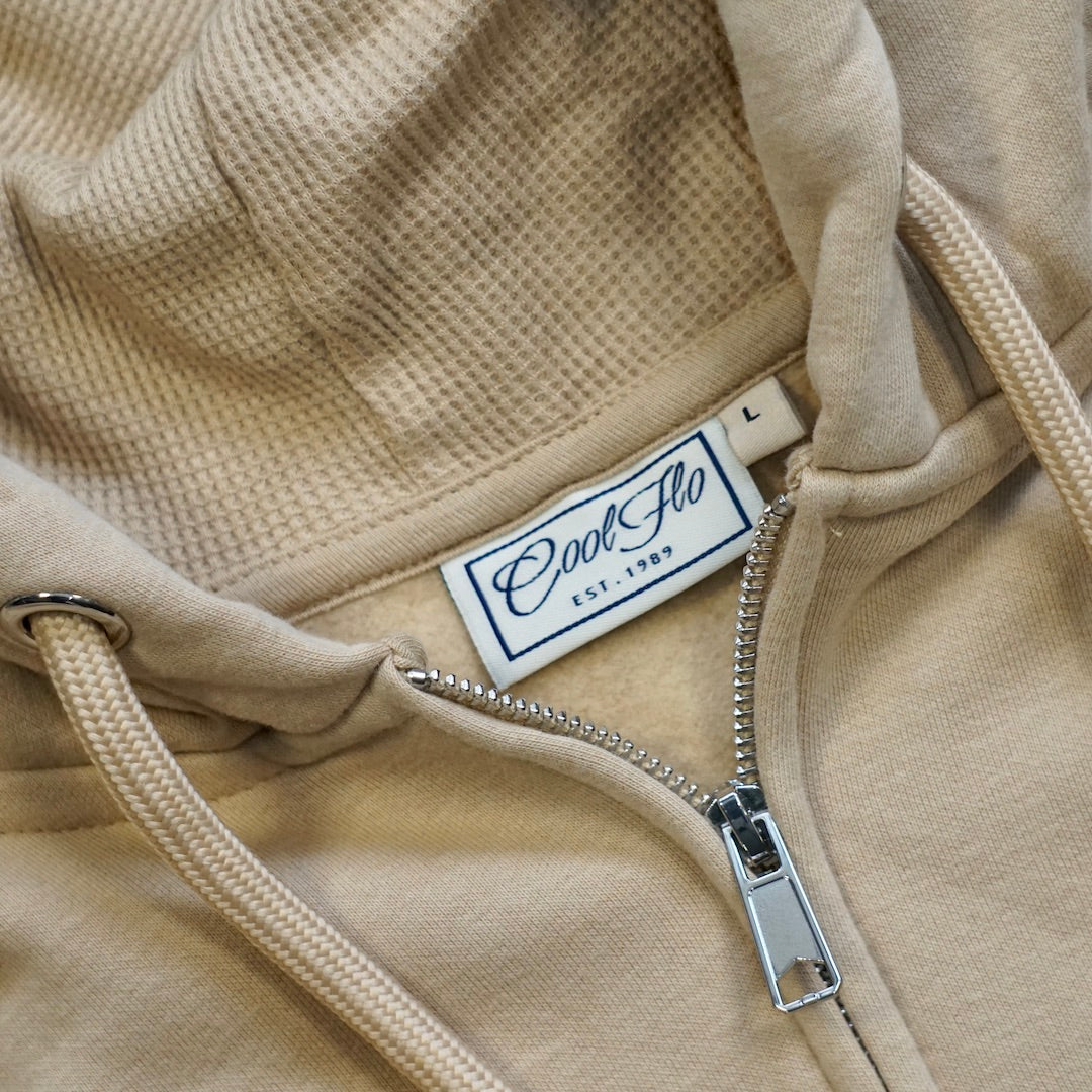 Close-up of neck detail on Desert Sand zip hoody with Cool Flo 3D puff embroidered badge in brown, white and orange.