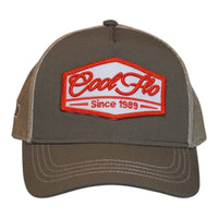 A trucker cap with an olive front and khaki mesh back, featuring a prominent embroidered front patch that reads 'Cool Flo Since 1989' in red and white.