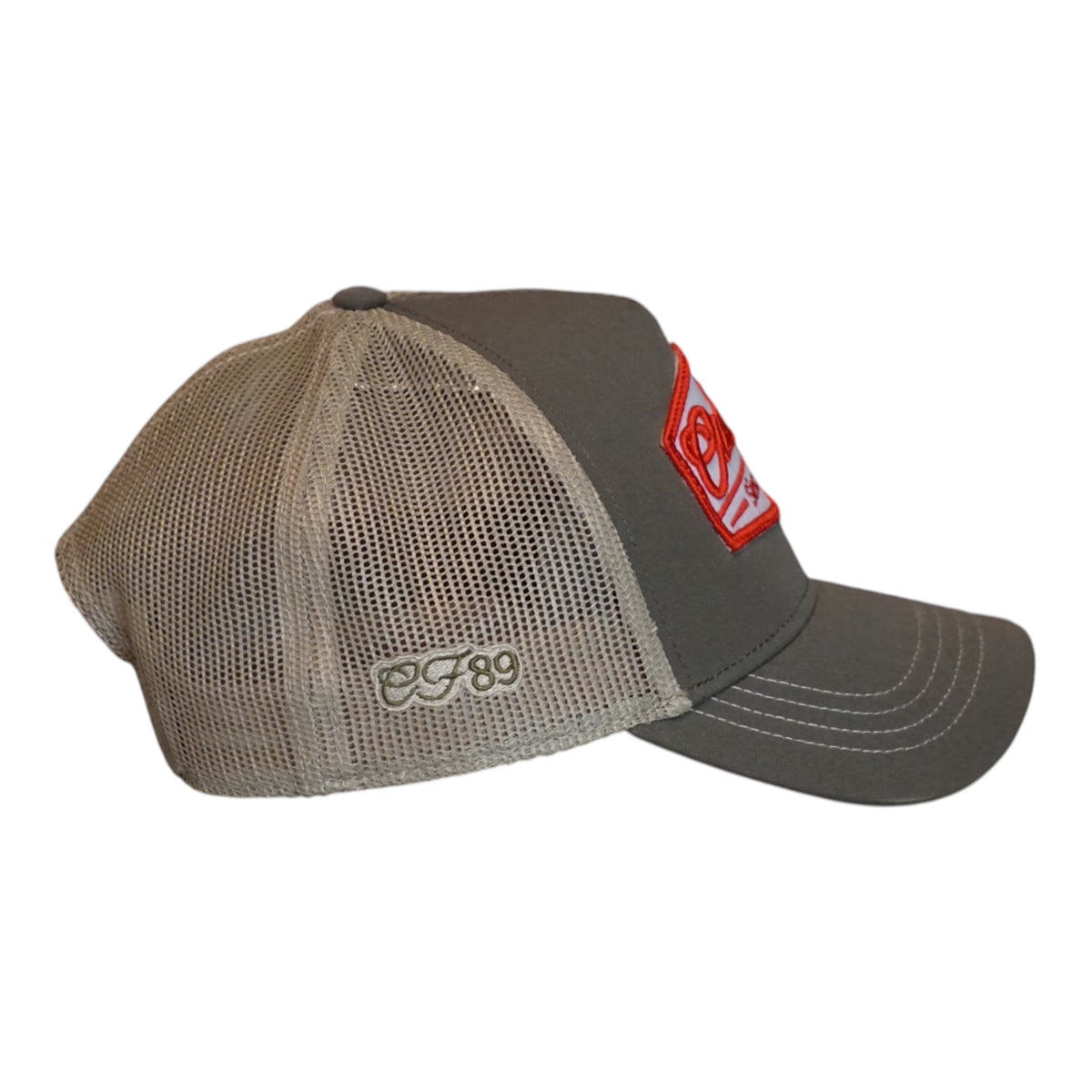 A trucker cap with an olive front and khaki mesh back, featuring a prominent embroidered front patch that reads 'Cool Flo Since 1989' in red and white - side view.