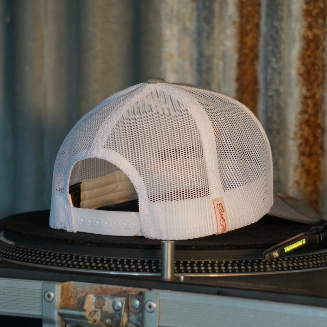 Centreforce Summer in the City event trucker cap (heather grey & white) placed on a record turntable 