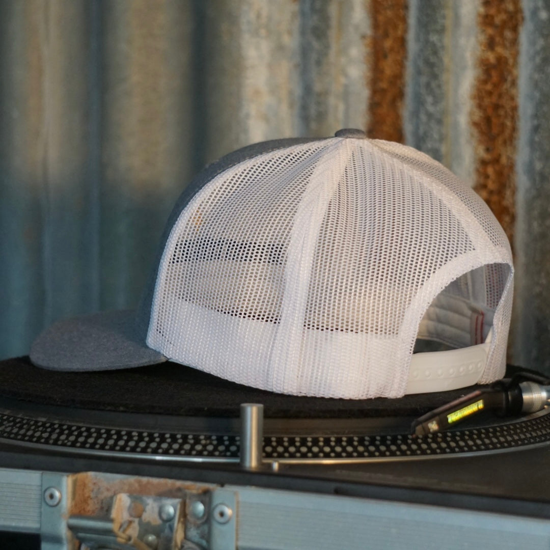 Centreforce Summer in the City event trucker cap (heather grey & white) placed on a record turntable 