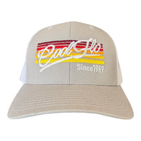 Cool Flo Sunlines trucker cap with a silver grey front and white mesh. Cool Flo logo and Since 1989 embroidered against a background of graduating lines in sunset colours. (Front view.)